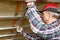 Drywall plaster wall metal fixation. Man holding metal ruler against metal frame on unfinished attic ceiling