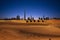 Dubai camel caravan travel with sand dunes and desert sunset