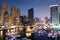 Dubai marina with boats and buildings with gates at night with lights and blue sky