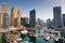 Dubai marina with boats and buildings with gates, United Arab Emirates