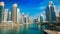 Dubai Marina under blue sky, with boats and skyline