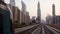 Dubai, UAE - 10th october, 2022: metro train on railway in Dubai with museum of future and sunset sky background