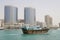 Dubai UAE A dhow old wooden sailing vessel cruises down Dubai Creek in front of the Rolex Tower.