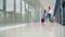 Dubai, UAE, March 2020: Passengers with suitcases walking on the terminal airport. Woman and little girl with luggage