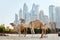 Dubai, UAE, November 2019 Four camels stand on the beach against the backdrop of modern skyscrapers in the Dubai Marina district