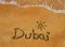 Dubai word on sand beach background