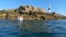 Dublin. Ireland - 04.15.2021: Fishing boat on the sea with island in background. Glitter sea water.