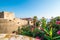 Dubrovnik city walls and Minceta tower, panoramic view of city. Green tress, palms and oleander flower. Beautiful ancient city and