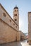 Dubrovnik, Croatia - Aug 22, 2020: Empty stradun street view of Franciscan church bell tower in morning sunrise