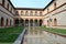 Ducal Court of Sforza Castle in Milan and its ancient medieval arcades, reflected in the pool water.