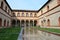 Ducal Court of Sforza Castle in Milan and its ancient medieval arcades, reflected in the pool water.