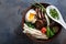 Duck noodles with egg and mushrooms in bowl on dark black stone texture background