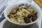 Duck noodles in a white bowl placed on a white wooden table.