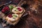 Duck rillettes pate toasts with sprouts on a wooden board. Dark background. Top View. Copy space