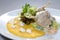 Duck in a sauce with vegetables, lettuce, corn porridge and cheese on a white plate