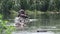 Ducks standing on small boulder in river