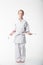 A duduka is standing in a kimano on a white background. Karate is insulated.