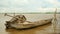 Dugout canoe next to wooden fish crate holds with bamboo poles on the edge of the river 