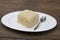 Dukan Diet. Fresh delicious diet cake at Dukan Diet on a porcelain plate with a spoon on a wooden background.