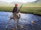 Dukha Boy rides reindeer across river