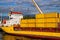 Dumaguete, the Philippines - 10 Mar 2020: yellow cargo ship in port, with containers loaded. Maritime shipping