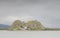 Dumbarton castle rock volcano mountain island illuminated by winter sun under dark grey sky Dunbartonshire Scotland UK