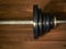 Dumbbell barbell on brown wood background.