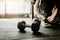 Dumbbell on the floor in gym with woman in background