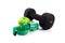 Dumbbell, green apple and measuring tape on a white background.