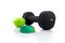 Dumbbell, green apple and measuring tape on a white background.