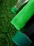 Dumbbell, green towel and a bottle of water on grass. Concept of sports and healthy lifestyle.
