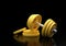 Dumbbell with yellow plates isolated on black background