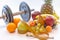 Dumbbells and assorted fruits and meter healthy lifestyle weight loss concept