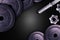 Dumbbells on carbon background. Dumbbells and weights are lying on the floor in the gym. Barbell set and gym equipment. Metal