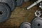 Dumbbells on carbon background. Dumbbells and weights are lying on the floor in the gym. Barbell set and gym equipment. Metal