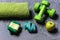 Dumbbells in green color, apple, towel, hand band and tape