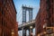 Dumbo - The famous Manhattan bridge between two red brick buildings in Brooklyn