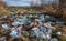 Dump of plastic bottles in autumn field on outskirts of town