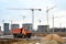 Dump truck on the construction site against tower cranes and constructing a new residential building.