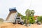 Dump truck dumps its load of rock and soil