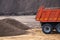 Dump truck and a pile of sand at a construction site close up