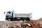 The dump truck is pouring soil out of the pickup truck. isolated on white background.