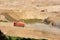 Dump truck transports sand in open pit mine. Excavator in quarry excavate from ground which sand and gravel. Mining industry