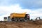 Dump truck transports sand and other materials at construction site. Road repair, construction equipment works, background