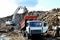 Dump truck unloading of broken concrete slabs demolition waste on landfill. Reuse concrete.