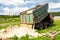 The dump truck unloads sand. The truck dumped the cargo. Sand and gravel. Construction site, materials warehouse.