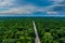 Dump trucks carrying goods on the highway. white truck driving on asphalt road through a green forest