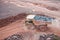 Dumper truck driving in an active quarry mine of porphyry rocks.