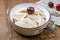 Dumplings with cherries on a plate on wooden table