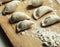 Dumplings with meat laid out on a wooden tray